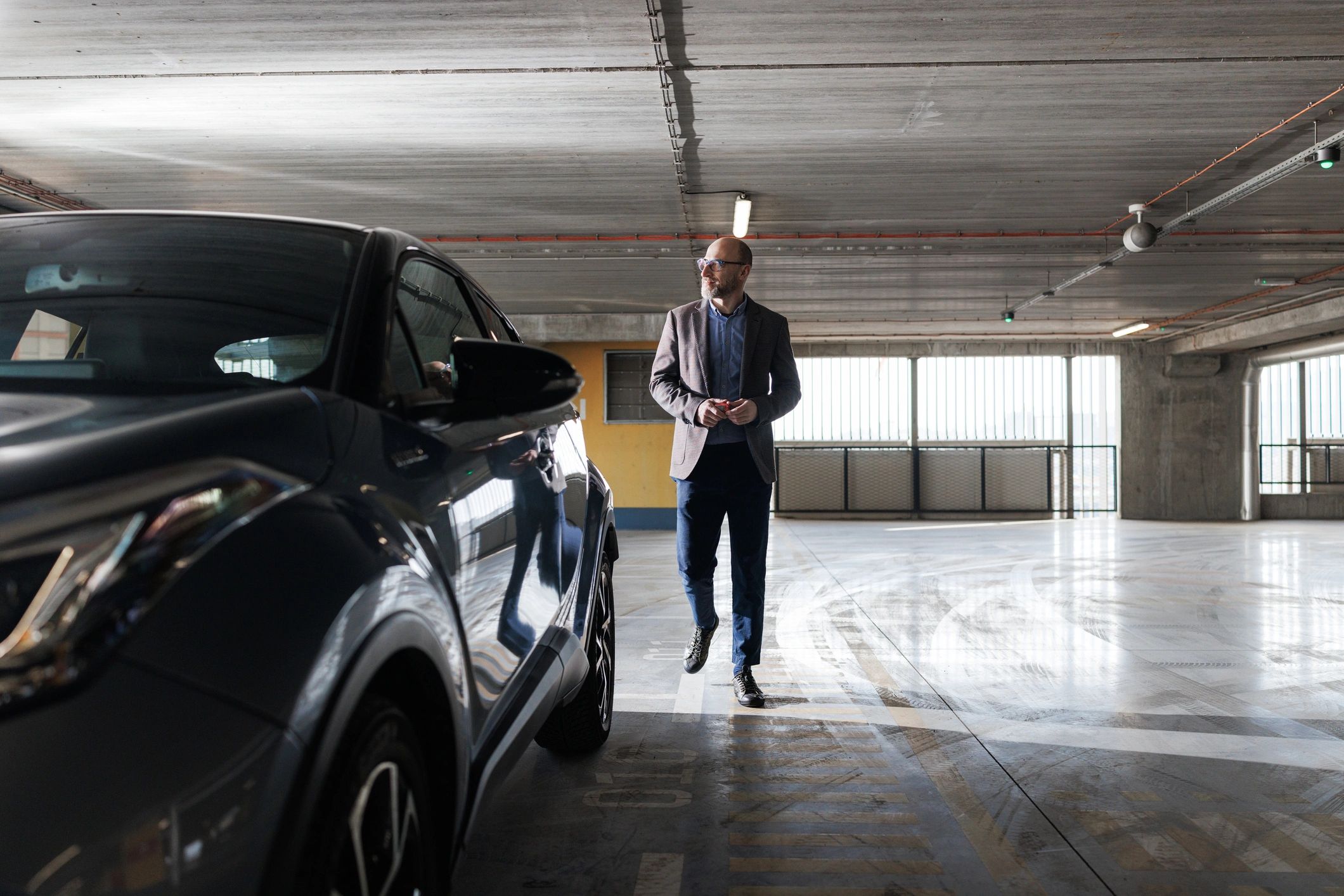 Person using a car key beside a vehicle